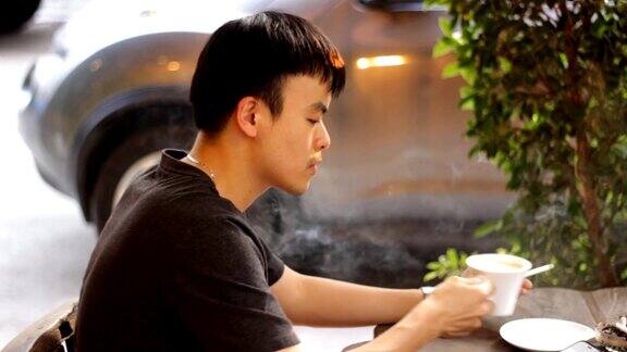 男人一边抽烟一边使用智能手机一边喝咖啡
