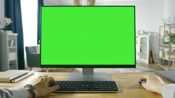 职业自由职业者从家里在绿色模拟屏幕个人电脑上工作的第一人称视角男人的类型浏览互联网在他舒适的客厅里使用电脑