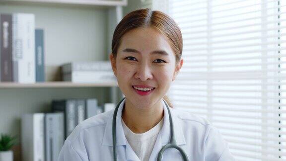 肖像亚洲女医生制服与听诊器看镜头和微笑医学概念