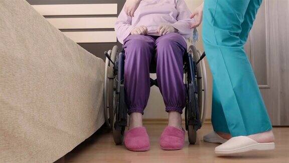 年轻的护士照顾年长的残疾妇女在轮椅上