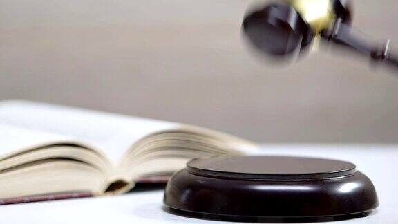 法官打了一下木槌打开了桌上的法律书宪法和正义