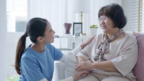 年轻的亚洲妇女或护士在家照顾手在老祖母的肩膀给予支持同情老年妇女或老年人在辅助生活家庭照顾精神健康疾病救济