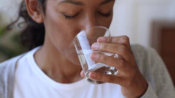 口渴脱水的非洲妇女拿着玻璃杯喝水特写镜头