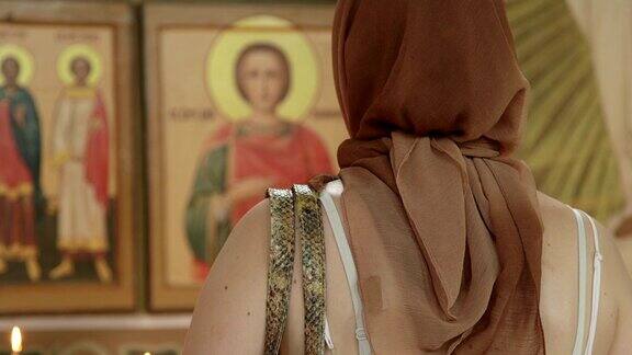 在东正教会前在圣像前祈祷的基督教妇女