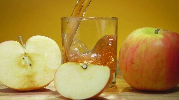 在黄色背景上苹果汁倒在苹果片旁边