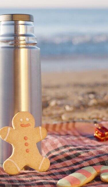 垂直视频圣诞节的早晨热茶和自制姜饼放在格子毯子上背景是大海