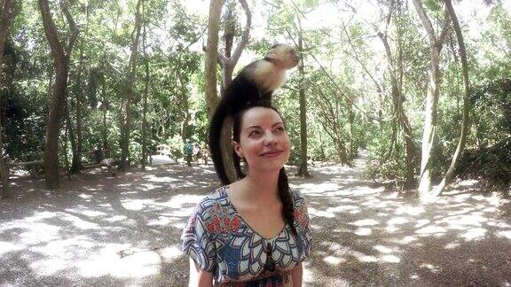 一个女人把一只猴子顶在头上