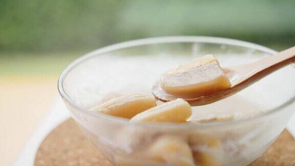 用木勺盛着泰国传统甜点椰奶香蕉泰国菜