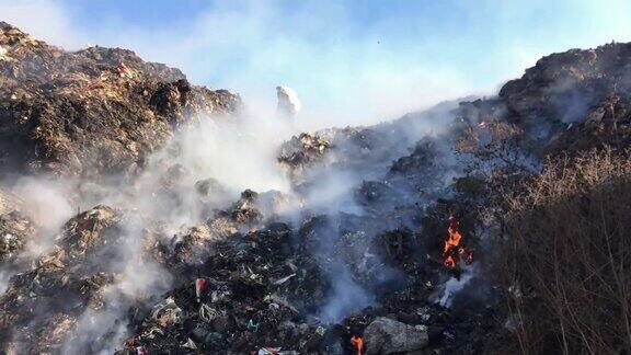 在垃圾场或填埋场焚烧垃圾在环境中释放有毒烟雾污染空气环卫工人在分拣垃圾