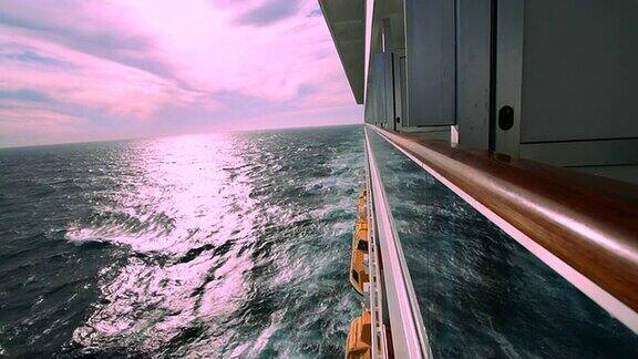 邮轮尾流和外侧船舱的粉红色天空