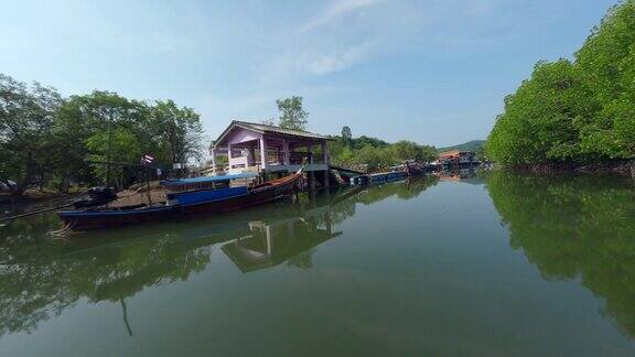鸟瞰图飞行平静的河流之间的绿树林村港口亚洲渔船