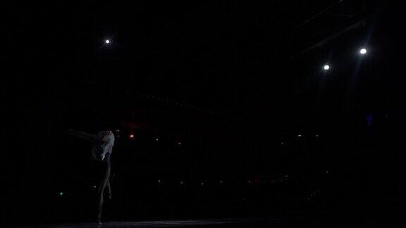 单人表演片段交际舞舞者在舞台上的白色衬衫裸露的躯干晒黑从舞台到黑暗的大厅后面的聚光灯跨过去跨步跳步弓步链式旅行远的距离