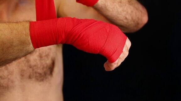 男子拳击手用红绷带包裹手腕