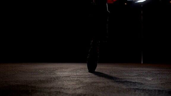 黑暗中舞台上穿着尖角鞋的芭蕾舞者的脚