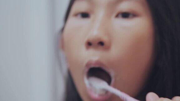 亚洲女孩在浴室里勤奋地刷牙慢镜头