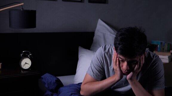 年轻的亚洲男子失眠躺在床上