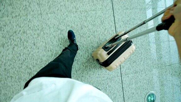 一名男子拿着行李在机场行走