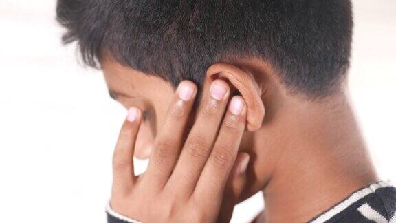 十多岁的男孩耳朵疼痛触摸他痛苦的耳朵