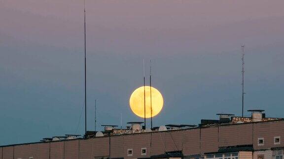 一个多层建筑屋顶上的满月正在上升