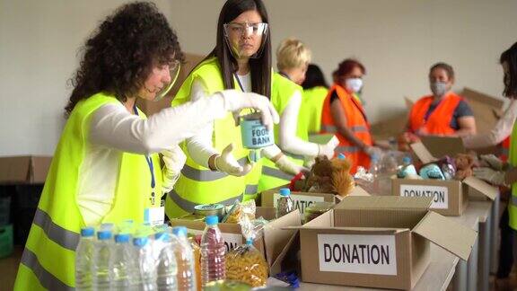 大流行期间志愿者在仓库收集捐赠的食物