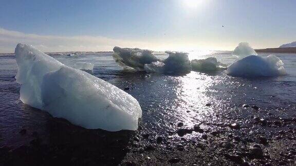 美丽的日落在著名的钻石海滩冰岛这个熔岩沙海滩充满了许多巨大的冰宝石放置在冰岛东南部的冰川泻湖Jokulsarlon冰岩与黑色沙滩