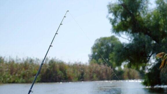 河上小船上的钓竿抖动着鱼儿试着钓鱼饵摇钓竿