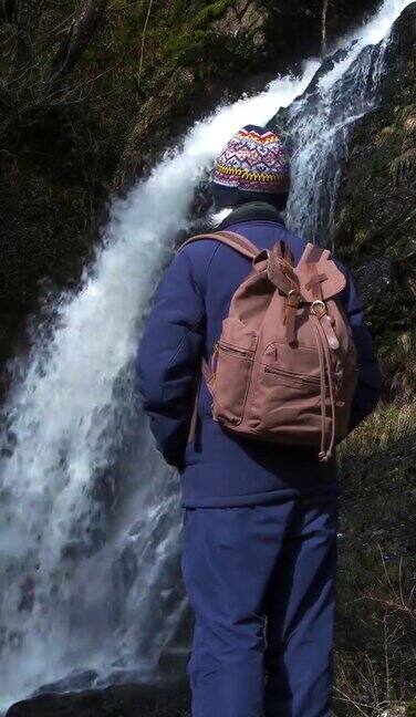 退休男子站在瀑布旁