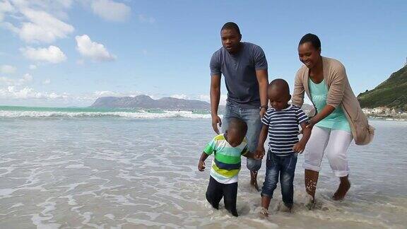 非洲家庭在海滩上散步