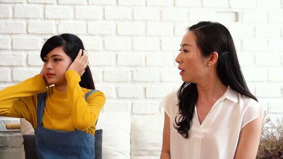 争吵恼怒的亚洲十几岁的女儿和沮丧的中年母亲