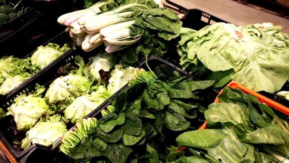 新鲜绿叶蔬菜在超市塑料板条箱的特写