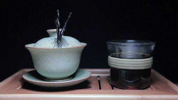 茶杯蝴蝶竹桌深色背景高清画面