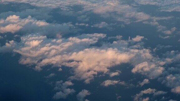 飞机飞行一架飞机的机翼在夕阳西下的云朵上空飞行从飞机窗口看到的景色飞机飞机乘飞机旅行4kUHD视频
