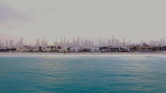美丽的鸟瞰图的城市景观黎明与海滩在前景和摩天大楼在后面迪拜阿联酋