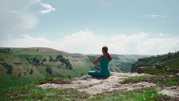 女孩在莲花坐练瑜伽美丽的山景