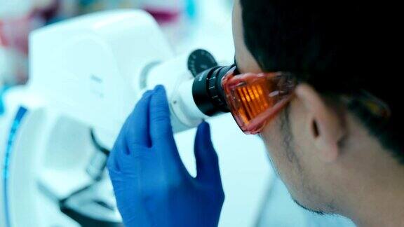 研究人员在实验室里观察显微镜慢镜头