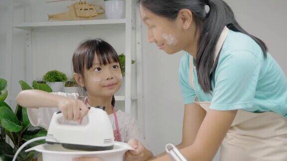 亚洲女孩在家里和姐姐一起拌面团做自制饼干生活理念