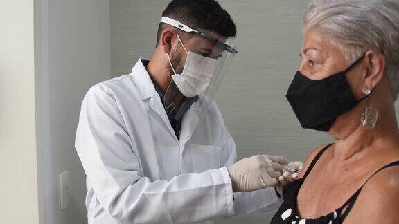 医生为老年妇女注射冠状病毒疫苗