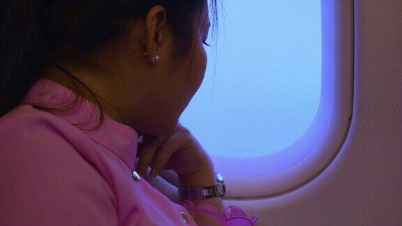 一名亚洲女子向飞机窗外望去