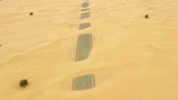 从上面俯瞰迪拜沙漠中部被沙丘覆盖的废弃道路的惊人鸟瞰图阿拉伯联合酋长国迪拜