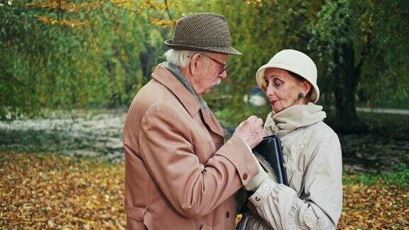 一个老人在秋天的公园里安慰一个伤心的女人