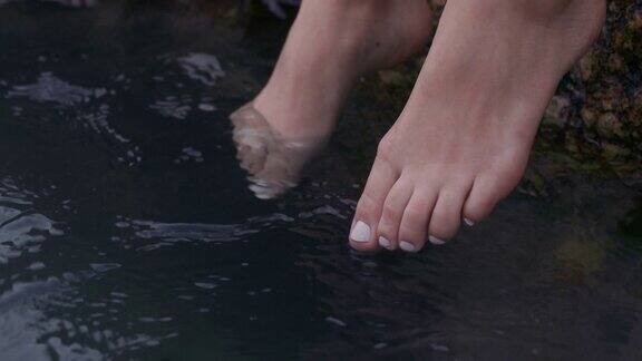近距离女子脚玩水赤脚享受平静的海滩