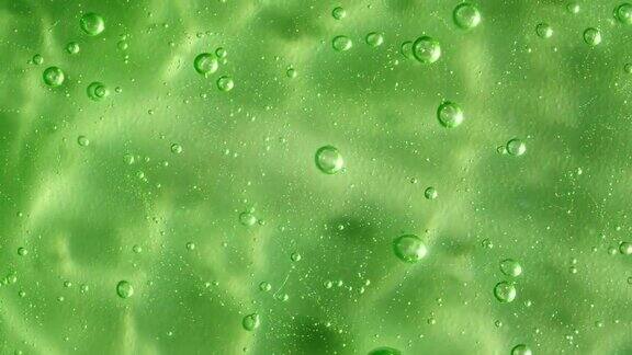微距镜头空气气泡在透明化妆品液体凝胶霜绿色化妆品流体纹理与泡沫慢动作