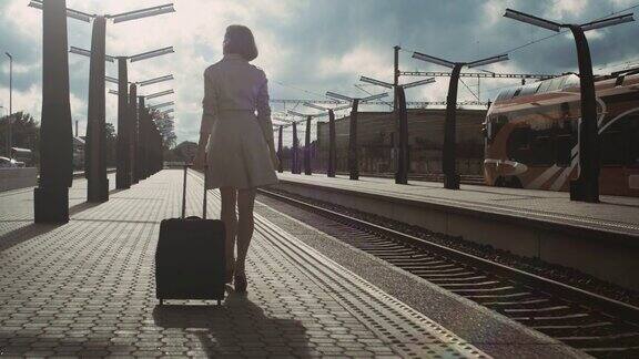 紧接着是自信的女人带着行李走过火车站的照片