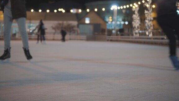 晚上在城市的露天溜冰场上一群不认识的人在骑着他们的腿圣诞集市上的公共溜冰场人们在乌克兰基辅的溜冰场上滑冰