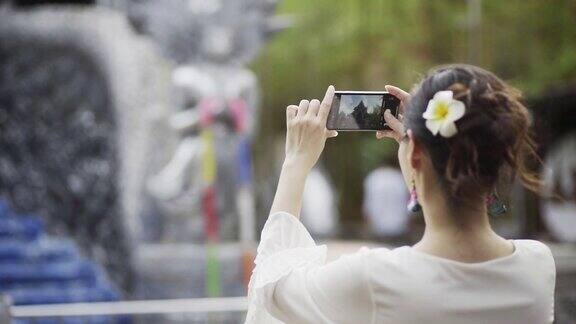 亚洲女性用智能手机拍摄美丽的风景
