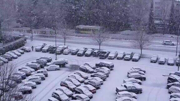 鸟瞰图交通流和停车场在寒冷的暴风雪雪天