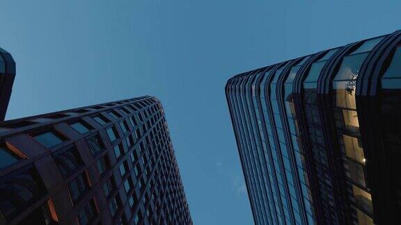 在傍晚拍摄两幢有大窗户的高楼办公楼在天空的映衬下