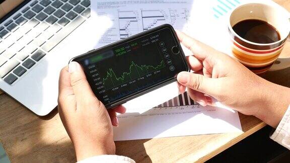 商业人士用智能手机分析股票市场数据