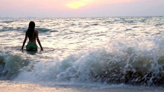 穿着比基尼的女人在海滩上玩水后视图快乐的女性游客在暑假