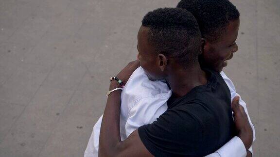 快乐的年轻非洲移民在街头拥抱-慢镜头